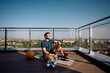 © Drazen - Relaxed athletic man having water break while working out on terrace.