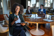 © Miljan Živković - Smiling businesswoman using smart phone during office meeting