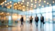 © Yurgentum - Out-of-focus image of people walking in modern office hallway, bright lighting.