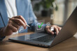 © inthasone - Business professional performing digital document verification and compliance management on laptop. Quality assurance, audit workflow, approval process, data security and operational control concept.