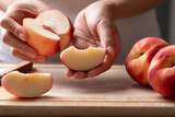 Woman hands holding a sliced fresh white peach, ready to eat