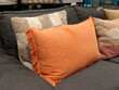 © brostock - Orange and striped textured cushions on a dark grey sofa