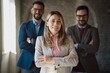 © Novak - Portrait of three diverse business people standing in modern office