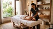 © Morepic - A woman receiving a back massage from a professional therapist in a serene, tropical spa setting with shelves of towels and oils.
