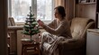 © Aliaksandra - holiday spirit, a lone woman decorates a small christmas tree in her cozy micro-apartment