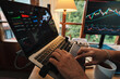 © Luis Herrera/Stocksy - Trader hands working with Stock chart on Multiple Screens