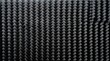© Ryan - Dark woven carbon fiber texture background showing an intricate pattern of high-tech composite material