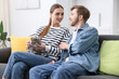 © New Africa - Couple with their cute cat on sofa at home