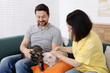 © New Africa - Couple with their cute cats on sofa at home