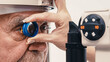 © wedmoments.stock - Ophthalmologist examining an elderly man's eyes using a diagnostic lens in a modern eye clinic. Concept ophthalmic diagnostics, retinal evaluation and preventive eye care.
