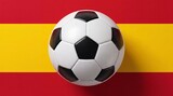 A professional black and white soccer ball centered on the red and yellow background of the Spanish national flag, representing sports and national pride.
