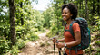 © Len_mik - Smiling African American woman hiking on forest trail. Happy black female backpacker with trekking poles on outdoor adventure