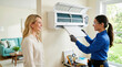 © Len_mik - Female HVAC technician showing a clean air filter to a smiling homeowner. Professional service woman explaining indoor air conditioner maintenance to a customer