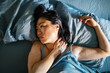 © Davor - Woman with neck pain awake in bed at home