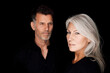 © Westend61 - Portrait of mature man and mature woman wearing black clothes in front of black background