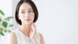 © YT - 白い室内で横を見つめながら首元に手を添える若い日本人女性の清潔感あるスキンケア美容イメージ