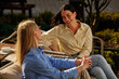 © bernardbodo - Young women laughing enjoying friendship at outdoor cafe