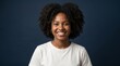 © Andre - Beautiful young black woman with curly hair smiling and looking over her shoulder against a grey studio background