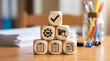 © Taufik - Wooden blocks stacked in a pyramid showing business management and administrative workflow icons on a desk.