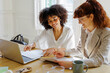 © BONNINSTUDIO/Stocksy - Diverse professionals collaborating on paperwork in modern office