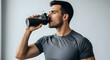 © Fizzah - Man Drinking Water from Bottle in Bright Indoor Setting with Focused Expression