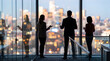 © Buxuan - Business professionals discussing strategy overlooking city skyline