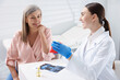 © New Africa - Doctor showing dental implant model to woman during appointment in clinic