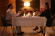© New Africa - Date. Lovely couple with glasses of red wine at table indoors