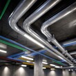©  Begnat - Industrial metal air ducts and multicolored pipes running along the ceiling of a modern commercial building?s underground utility and maintenance area with fluoresce