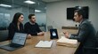 © Justlight - Two startup founders sit across from an advisor at a conference table, surrounded by a locked smartphone icon on a monitor, stacked legal folders, a laptop with blurred charts, and a compliance