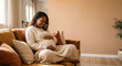 © JuanM - Pregnant woman relaxing on sofa cradling belly at home