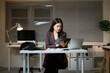 © Stella 16 - Asian Businesswoman Using Digital Tablet with Stylus Pen Working Late at Night in Modern Office