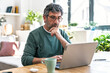 © Westend61 - Adult freelancer thinking while working on laptop at desk