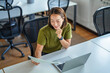 © Miljan Živković - Smiling asian woman working on laptop and checking document