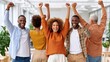 © Georgii - Diverse team of colleagues celebrating success with raised arms in a modern bright office together