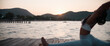 © Chaman Experience/Stocksy - Fitness professional stretching on pier during peaceful sunset
