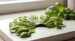 © CreativeLens - A beautiful chiffonade of fresh green basil leaves displayed in a delicate curved arrangement on a clean white kitchen marble cutting board background