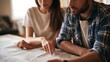© Bussakon - A couple sits at a table examining a physical map together  pointing to locations with focused attention