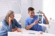 © New Africa - Doctor showing teeth scan and dental implant models to senior woman in clinic