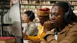 © DC Studio - Woman student wearing headphones smiles while working at desktop monitor, with books and classmates creating collaborative library computer class setting for digital learning.