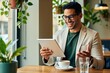 © Vadym - Man wearing glasses smiles looking at tablet in cafe. He wears a suit jacket and sits at table with coffee. He gestures with hand while reading e-mail on device.