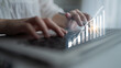 © InfiniteFlow - A person is typing on a laptop, with a digital graph overlay indicating business growth and financial success in a modern workspace environment. Impute