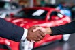 © Ajay - Two businesspeople shake hands, signing a car purchase deal in a dealership