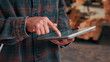 © peopleimages.com - Hands, tablet and scroll in carpentry workshop, check lumber order or online inventory management. Person, carpenter and tech for digital stock analysis or search woodworking merchandise app for info