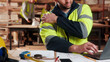 © peopleimages.com - Carpenter, hands and shoulder pain in workshop with laptop, fatigue or burnout in industry. Project planning, tech or man in woodworking factory with joint injury, physical strain or muscle stiffness