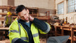 © peopleimages.com - Carpenter, man and neck pain in workshop with laptop, fatigue and burnout in industry. Project manager, stress and tech in woodworking factory with joint injury, physical strain and muscle stiffness