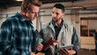 © peopleimages.com - Men, tablet and discussion in lumber workshop, carpenter and supplier with clipboard for timber delivery. Point, talk and people on tech for checklist, feedback and woodworking inventory management