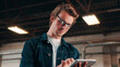 © peopleimages.com - Man, glasses and reading in tablet in factory, check order or online inventory management. Person, supervisor and tech for digital stock analysis or search merchandise app or website for information