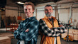 © peopleimages.com - Portrait, arms crossed and men in lumber workshop, carpentry apprentice and mentor in manufacturing. People, team confidence and smile with carpenter trainee, supervisor and woodworking production