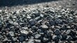 © IroHa - A pile of metallic-gray crushed stones on the ground, glinting under harsh sunlight.